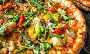 Apetyczna pizza bez mięsa z brokułami, pomidorkami, kukurydzą i rukolą.