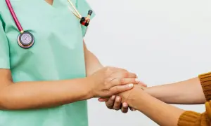 Un infermiere rassicura un paziente, superando la paura dei medici con un gesto di conforto.