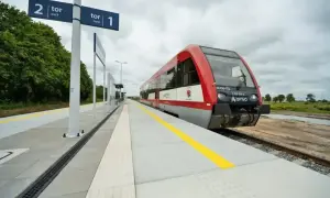 Czerwony pociąg Arriva czeka na peronie. Tablice wskazują tor 1 i tor 2, sugerując podróż między Toruniem a Lublinem.