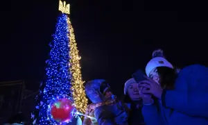 Choinka ozdobiona w barwach Ukrainy, ludzie robiący zdjęcia telefonami.