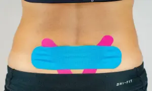 LWS tapen: Blaues und pinkes Kinesio-Tape stützt den unteren Rücken für mehr Stabilität und Schmerzlinderung.