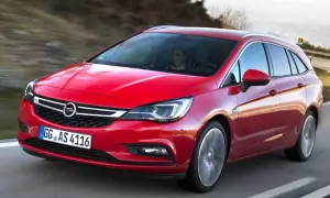 Röd Opel Astra kombi 2016 körs på en väg. En kvinna syns bakom ratten. Kanske ett problem med bilen?