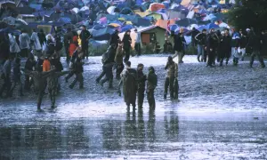 Muddy field with tents and people at Radiohead's iconic Glastonbury 1997 performance.