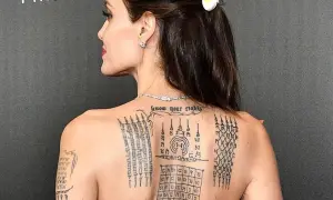Angelina Jolie z tatuażem sak yant na plecach, przedstawiającym skomplikowane wzory i napisy.