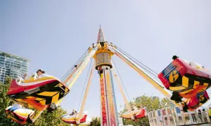 Karuzela "Hurricane" wesoło kręci się na tle błękitnego nieba, przypominając polski Disneyland.