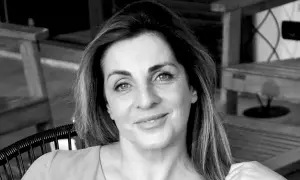 Ritratto in bianco e nero di una donna con capelli castani lunghi e mossi, occhi azzurri e un sorriso leggero. Sembra pensierosa, come se fosse andata a convivere ma non fosse felice.