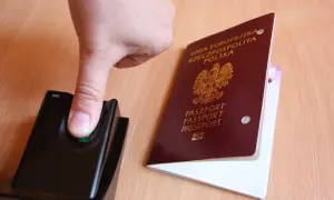 Palec na czytniku linii papilarnych obok polskiego paszportu. To pokazuje, ile ważny jest paszport w podróży.