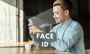 Uśmiechnięty mężczyzna korzysta z telefonu, który skanuje jego twarz. Technologia Face ID zapewnia szybki dostęp.