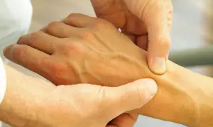 Arzt untersucht Hand, um Schmerzen in der Hand zu diagnostizieren.