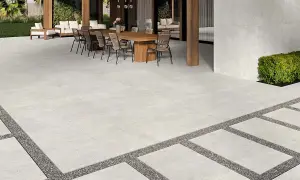 Terraza moderna con suelo de porcelánico que es resistente y elegante, rodeada de vegetación y mobiliario exterior.