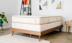 A Saatva mattress on a wooden bed frame, perfect for answering "cual es el mejor colchon para dolor de espalda.