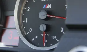 Wskaźnik pokazuje temperaturę oleju w silniku, która wynosi około 100°C. Obok znajduje się obrotomierz.