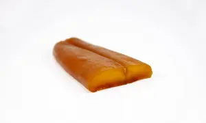 Zwei goldbraune, längliche Stücke Bottarga di Muggine liegen nebeneinander auf weißem Grund.