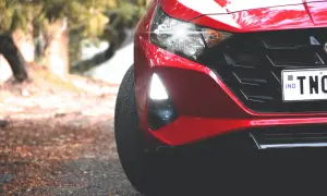 Czerwony Hyundai i20 z zapaloną żarówką do jazdy dziennej, gotowy do drogi.