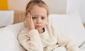 Ein trauriges Kind mit Kopfschmerzen, das sich im Bett ausruht. Vielleicht ist es ein Zeichen für schnelles Wachstum.