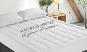 A plush mattress topper with two white pillows sits on a bed, promising a night of sweet dreams.
