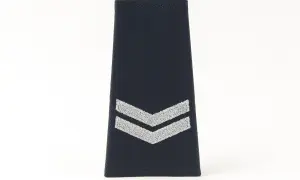 Granatowa naszywka z dwoma srebrnymi szewronami, symbolizująca stopnie w policji.