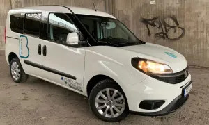 Vit Fiat Doblo med texten "BIOGAS" och "natural power" på sidan. En bil med ett potentiellt fiat doblo problem, kanske relaterat till dess biogasdrift.