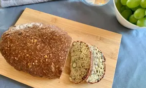Chleb z twarogu z ziarnami i orzechami, pokrojony na desce.