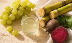 Un frasco con gel transparente, uvas verdes, caña de azúcar y remolacha. ¿Qué es la glicerina? Se obtiene de fuentes naturales como estas.