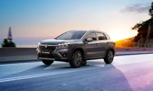Grå Suzuki S-Cross kör längs en väg vid solnedgången. Inga problem här, bara en vacker resa.