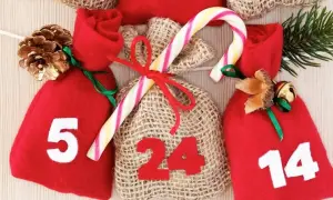 Kalendarz adwentowy z numerowanymi woreczkami (5, 14, 24) i świątecznymi ozdobami. Odliczanie do Bożego Narodzenia, czyli ile trwa adwent, jest tu widoczne.
