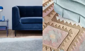 A dark blue sofa next to a light blue rug and a patterned rug with geometric designs.