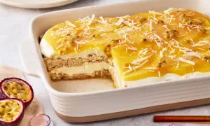 Ein saftiges Maracuja Tiramisu in einer Auflaufform, garniert mit weißen Schokostreuseln und Maracujakernen.
