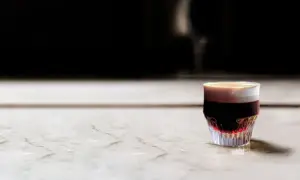 En vacker kaffe spanien, en lager på lager-drink med mörk espresso och krämigt skum, serverad i ett elegant glas.