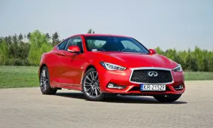 Czerwony Infiniti Q60s na tle zieleni. Eleganckie coupe gotowe do jazdy.