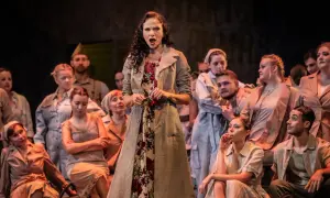 Carmen, w otoczeniu chóru, śpiewa z pasją, trzymając w dłoni czerwoną różę.