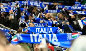 Tłum kibiców na meczu, trzymający niebieskie szaliki z napisem "ITALIA" i flagą Włoch. Emocje towarzyszące kibicowaniu podczas mistrzostw świata.