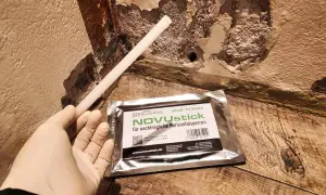Ein Handschuh hält einen Stab, der für die nachträgliche Horizontalsperre gedacht ist. Das Produkt NOVUstick verspricht, dass man die Horizontalsperre selber machen kann.