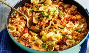 Hackfleisch-Nudel-Pfanne mit Zucchini und Paprika in cremiger Sauce, garniert mit Schnittlauch.