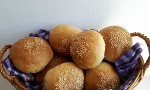 Koszyk pełen świeżych, pachnących bułek pszenno żytnich, posypanych sezamem. Idealne na śniadanie lub jako dodatek do obiadu.