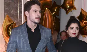 Adriana Kalska z partnerem na tle złotych balonów.
