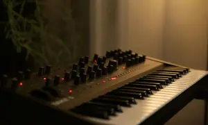 Elektroniczny instrument klawiszowy z licznymi pokrętłami i czerwonymi diodami, gotowy do tworzenia muzyki.