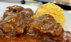 Un saporito gulash trentino, con carne tenera in salsa ricca e una porzione di polenta dorata.