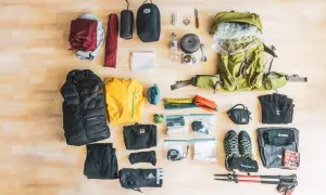 Alles, was man zum Wandern braucht: Rucksack, Zelt, Schlafsack, Kleidung, Schuhe, Wanderstöcke, Kochutensilien und Erste-Hilfe-Set.