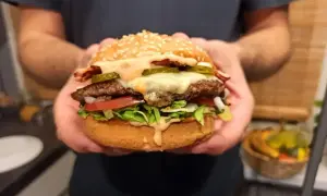 Idealny burger: soczysta wołowina, ser, chrupiąca sałata, pomidor, ogórek i sos. Oto jak składać burgera krok po kroku.