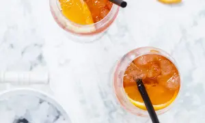 Dwa orzeźwiające drinki Aperol Spritz z plasterkiem pomarańczy i lodem. Idealne na letnie popołudnie.