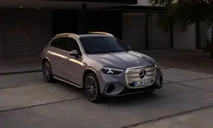 En elegant grå bil Mercedes står parkerad på en uppfart framför ett modernt hus.