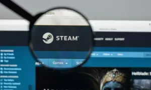Lupa powiększa logo Steam i fragment strony internetowej platformy z grami.