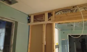 Pågående renovering av badrum med synliga rör och trästomme.