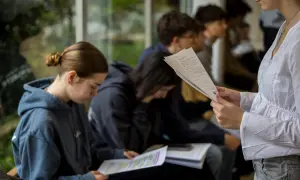 Estudiantes concentrados en sus apuntes, explorando las ventajas de estudiar en el extranjero y descubriendo nuevas oportunidades.