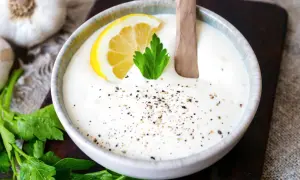Cremiger knoblauch dip mit Zitrone und Petersilie, bestreut mit Pfeffer. Perfekt zum Dippen!