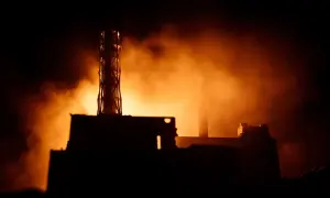 Mroczna sylwetka elektrowni, unosząca się mgła i pomarańczowe światło przywołują pamięć o tym, co wydarzyło się w Czarnobylu.