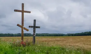 Trzy krzyże na tle pola i lasu. Jeden z nich ma napis "Spasi i Sochrani". Czy horoskopy to grzech?