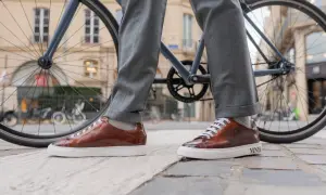 Eleganckie, brązowe sneakersy do garnituru, idealne na miejską przejażdżkę rowerem.