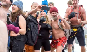 Grupa ludzi w zimnych warunkach, niektórzy bez koszulek, robi selfie. Metoda Wima Hofa niebezpieczna, ale ta grupa wydaje się cieszyć.